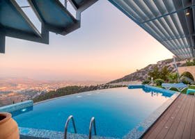 Infinity pool with breathtaking mountain and city views, perfect for a luxury tropical getaway.